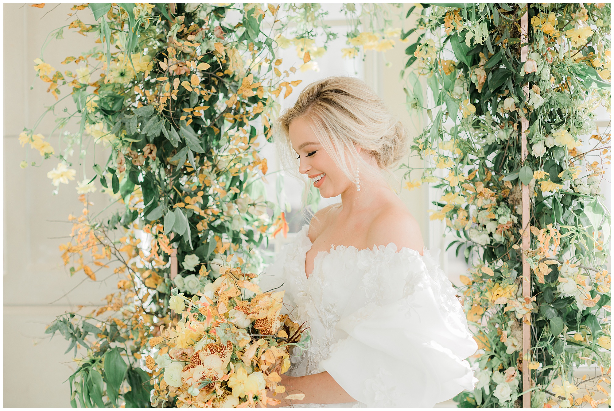 bride smiling down at yellow bouquet