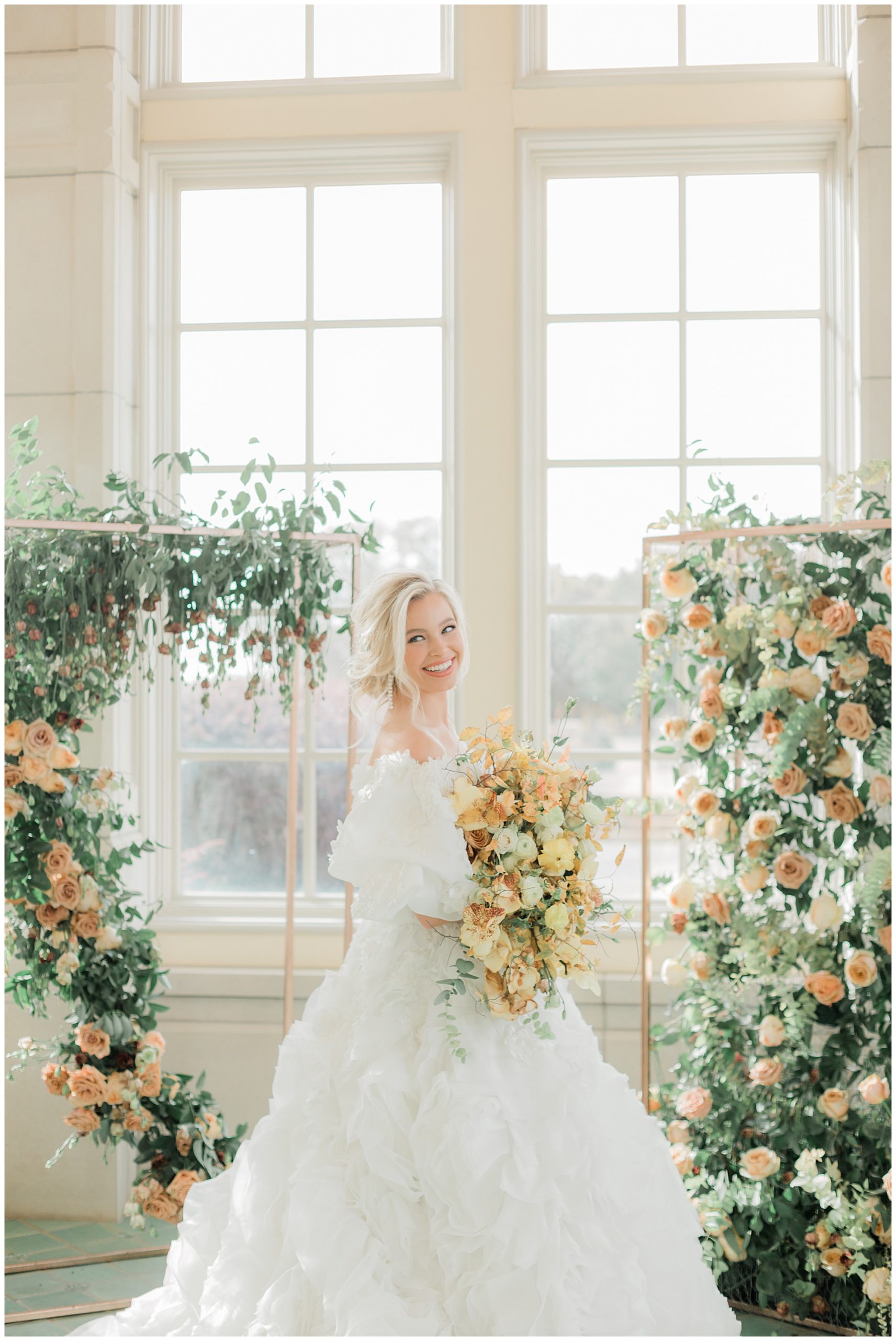 bride in ruffled wedding dress smiling at camera