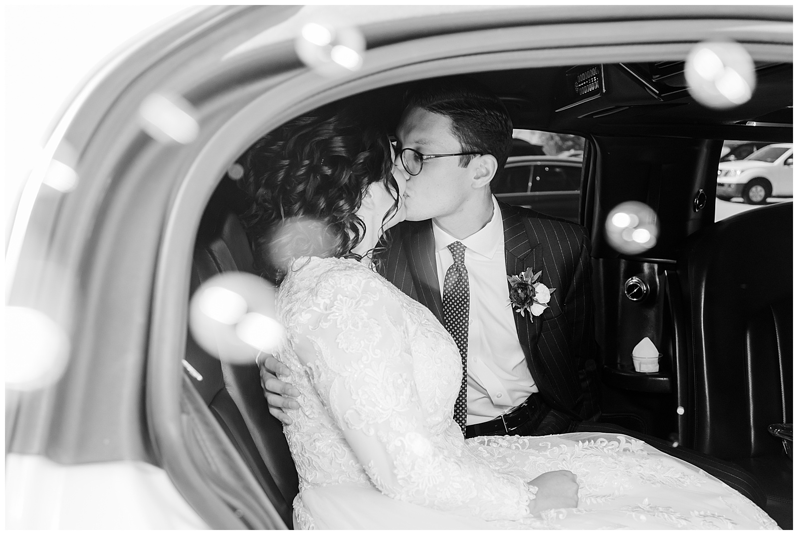 Bride and groom kiss in limosine
